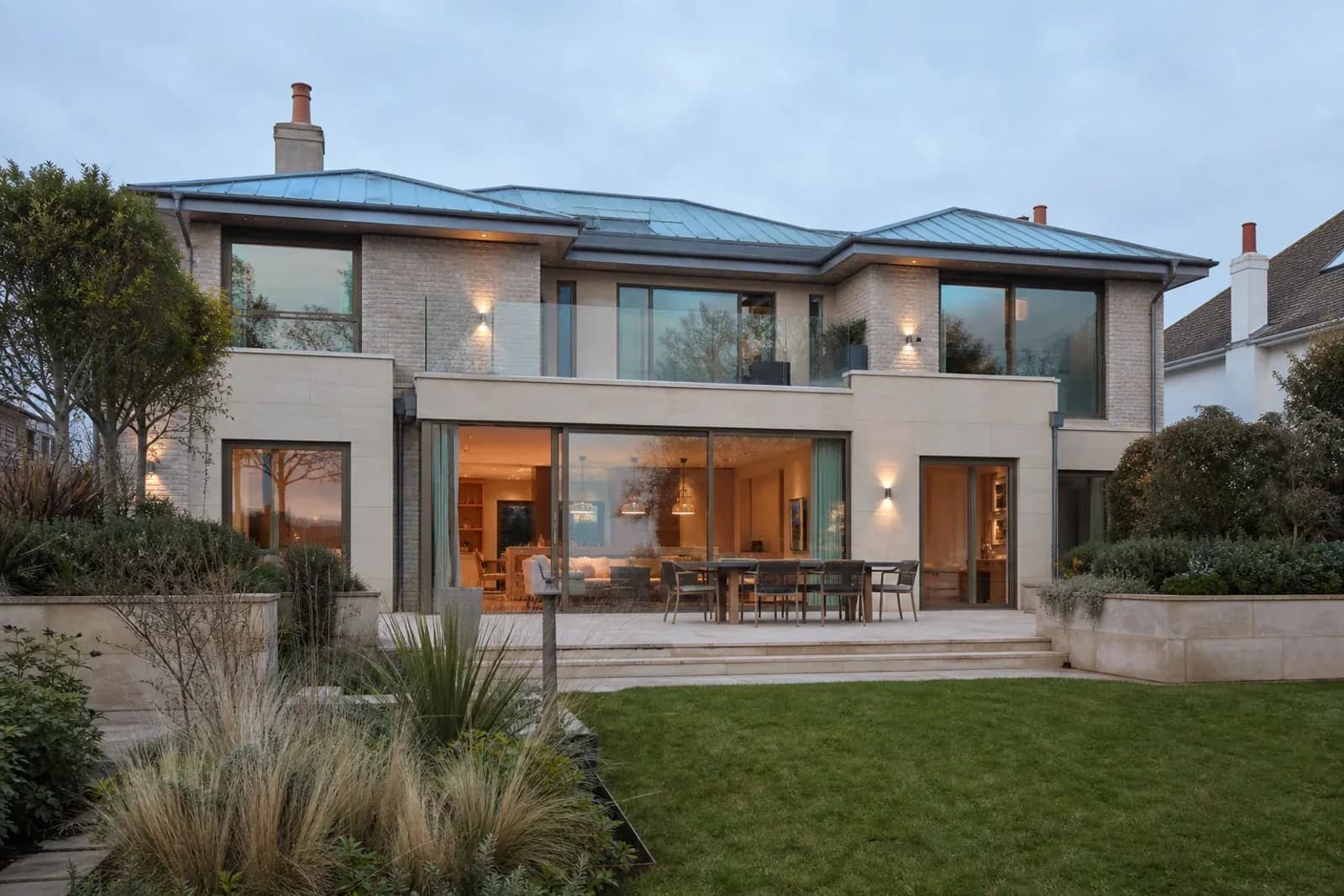 Remodelled coastal residence with pale brick, limestone and garden glazing